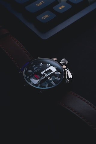 Close-up of a luxury watch with intricate details and a polished finish on a dark elegant background.