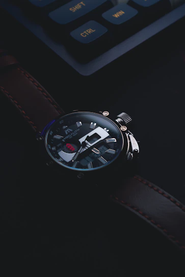 Close-up of a sleek, high-end sports watch with a leather strap resting on a vintage car dashboard.