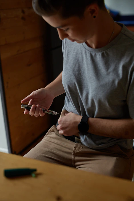 a person injecting insulin into stomach for diabetes management