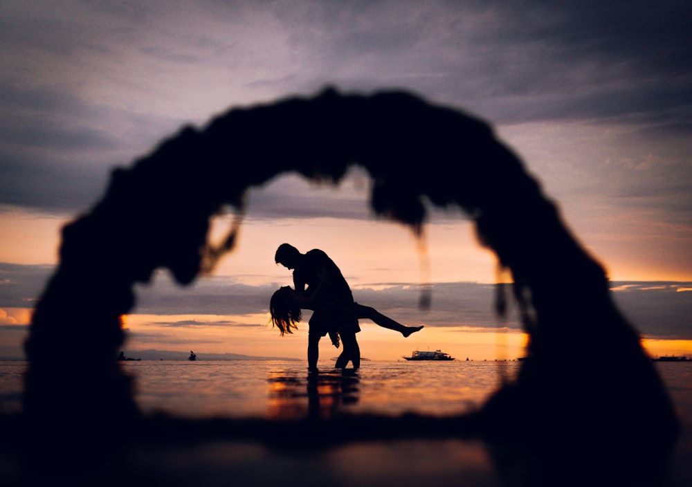 a silhouette of a man and a woman dancing on the beach