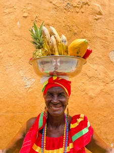 An inspiring, bright photo of an elderly man smiling while holding a basket filled with fresh vegetables, radiating health and happiness.