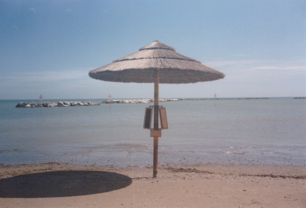 um guarda-sol sentado em cima de uma praia de areia