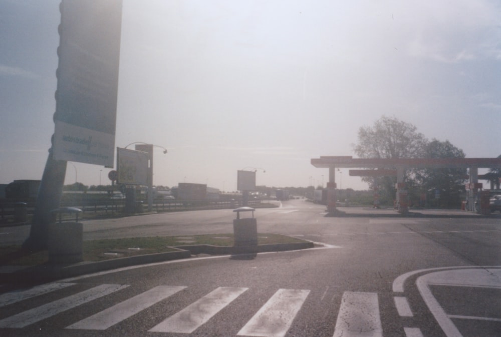 uma rua vazia com um posto de gasolina ao fundo