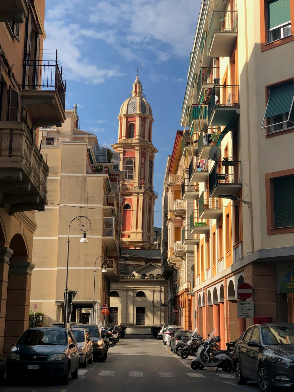 a city street lined with parked cars and tall buildings