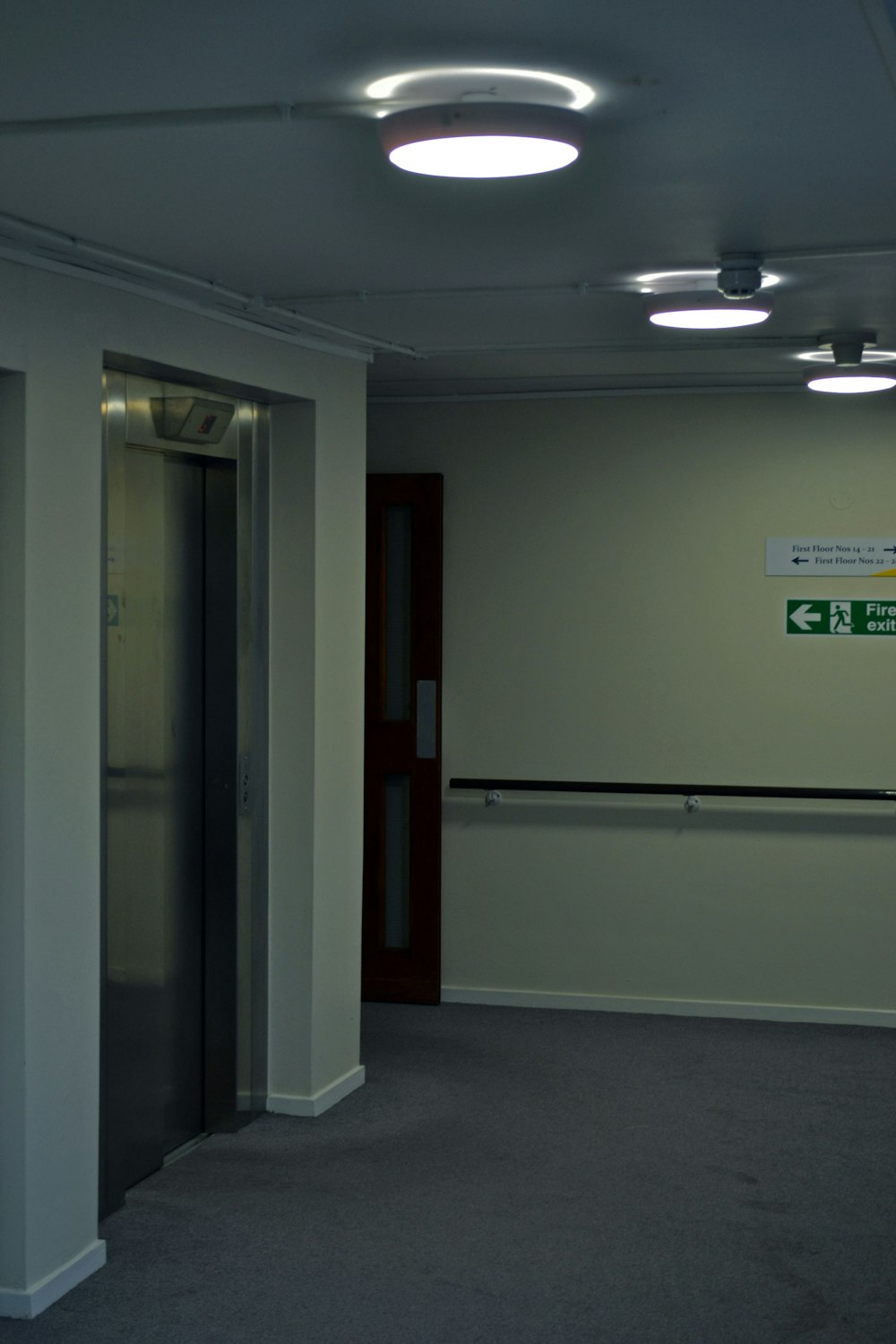 an empty room with a closed door and a sign on the wall
