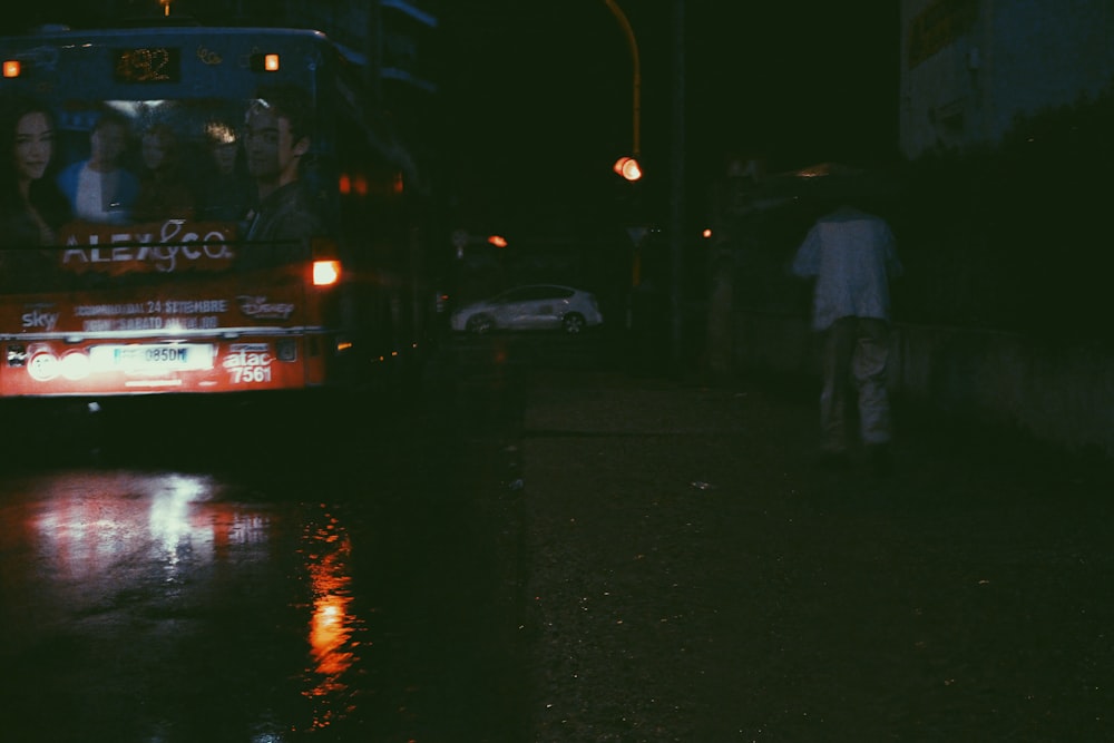 a bus driving down a street at night