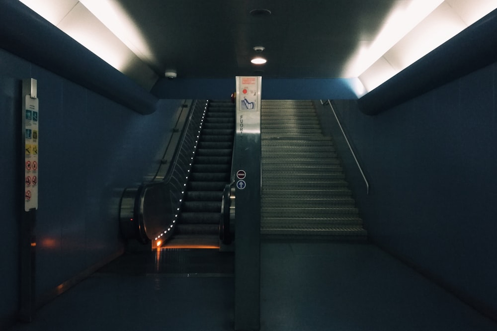 an escalator in a subway station with lights on