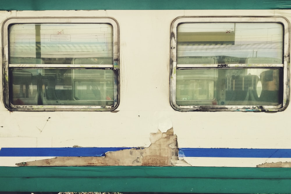 a green and white train car with two windows