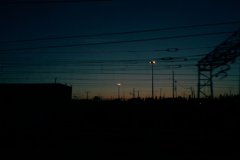 the sun is setting behind power lines in the distance