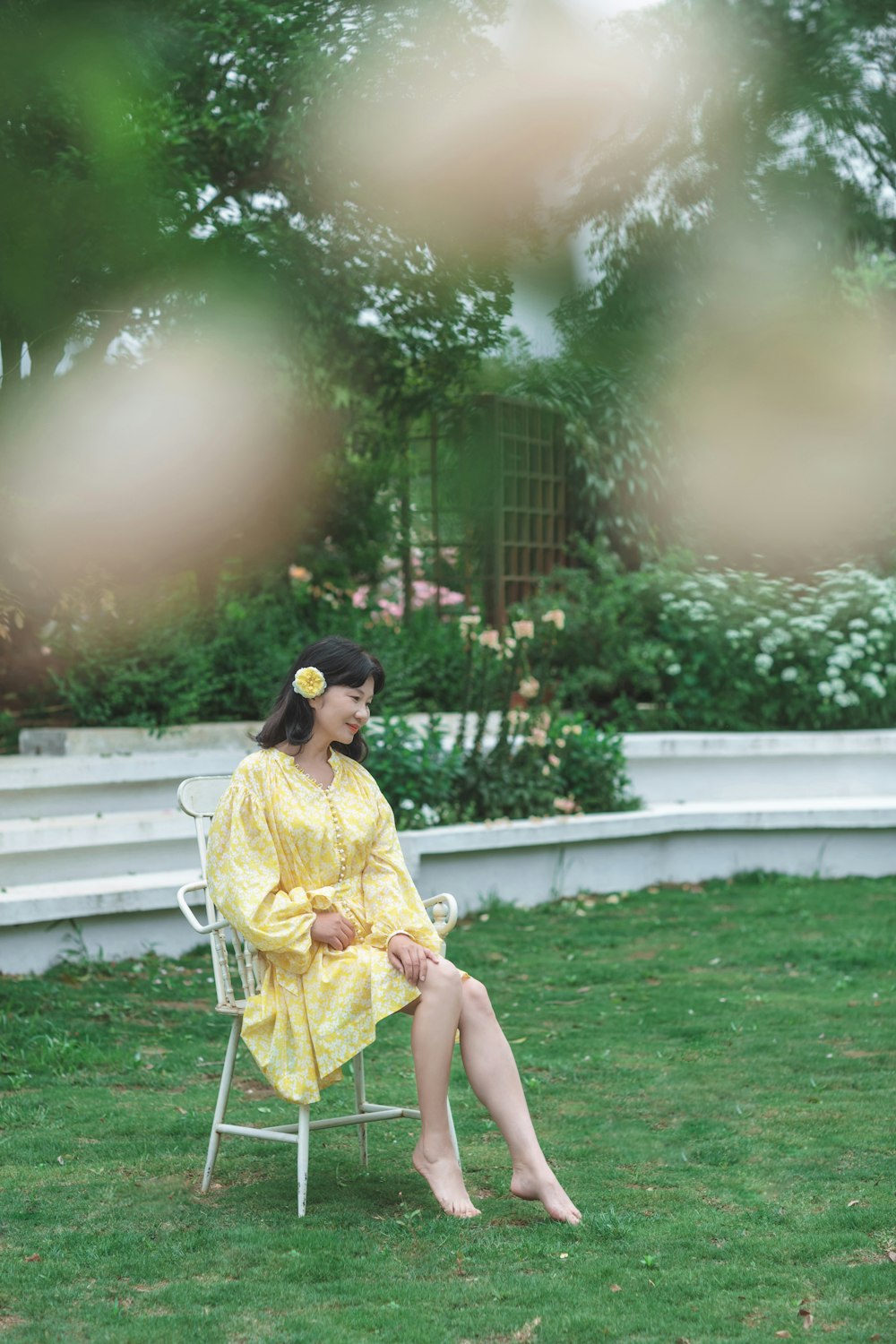 a woman in a yellow dress sitting on a white chair