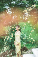 A serene woman in a flowing peach dress surrounded by blooming lavender and soft sunlight.