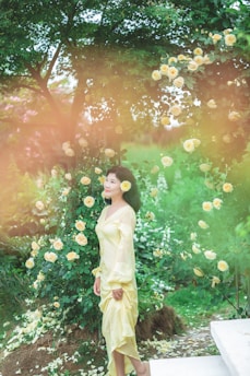 A serene woman in a flowing peach dress surrounded by blooming lavender and soft sunlight.
