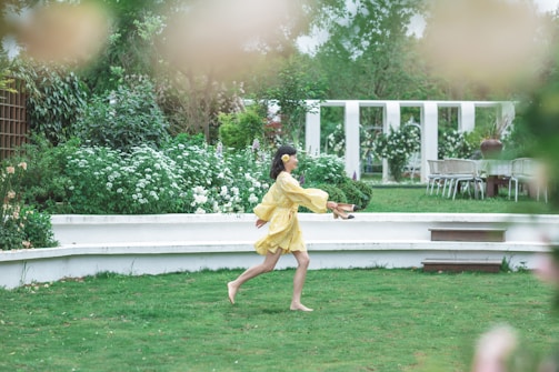 A joyful girl wearing a colorful party dress in a garden.