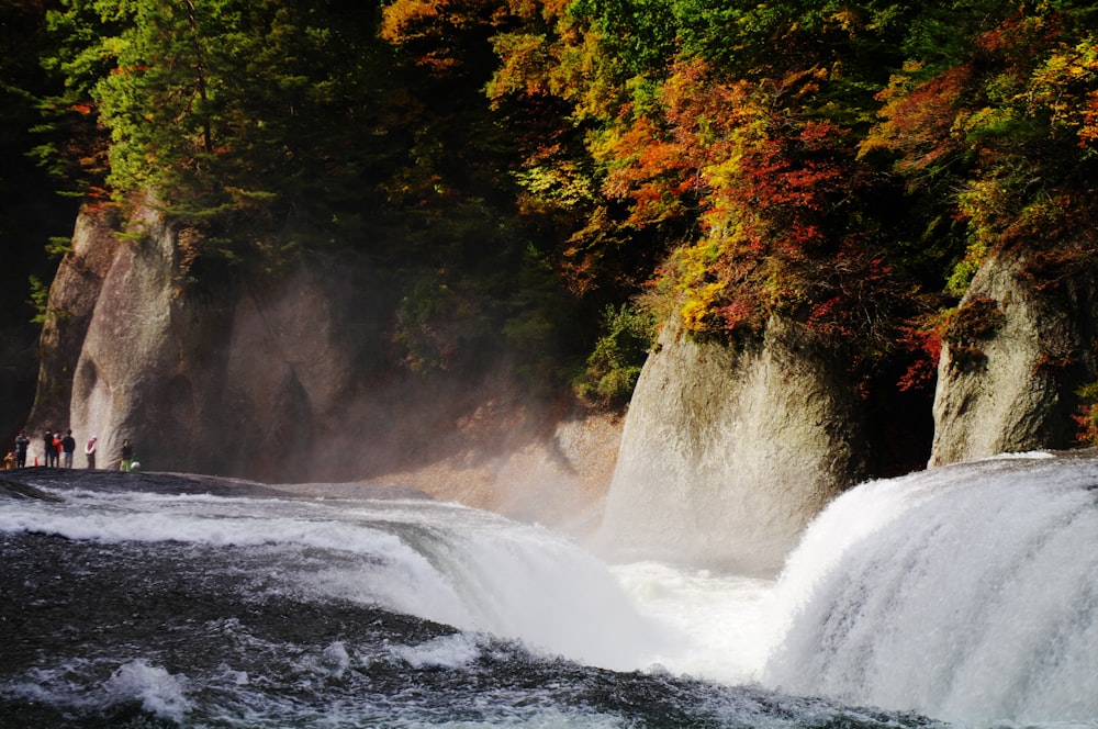 a group of people standing on top of a waterfall