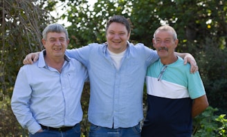 a group of three men standing next to each other