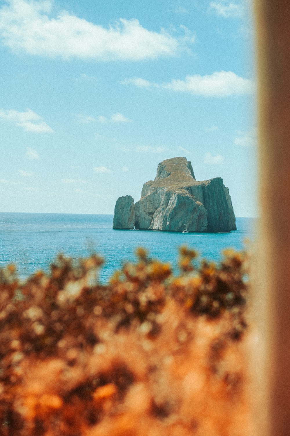 a view of a rock out in the ocean