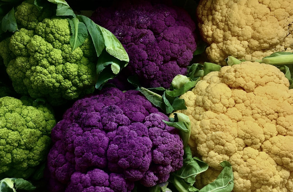 a pile of different colored cauliflower heads