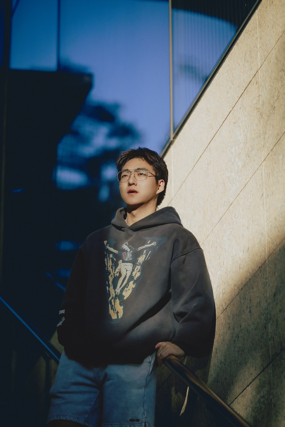 a young man standing in front of a wall