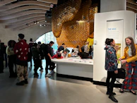 Team members collaborating enthusiastically around a large board illustrating the hive system.