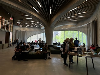 A bright, modern reading room with sleek yellow and black accents, comfortable seating, and rows of neatly arranged books under soft lighting.