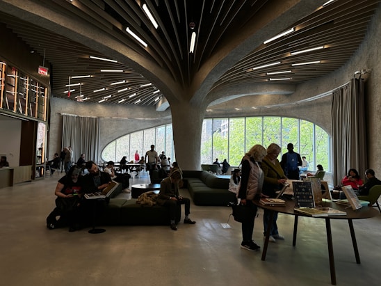 A bright, modern reading room with sleek yellow and black accents, comfortable seating, and rows of neatly arranged books under soft lighting.