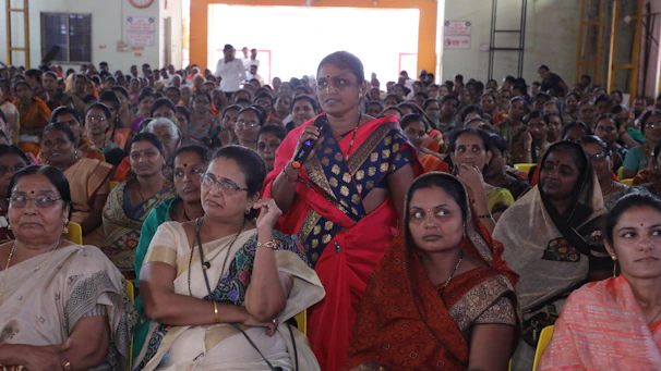 A speaker passionately addressing a crowd of women at a vibrant conference.