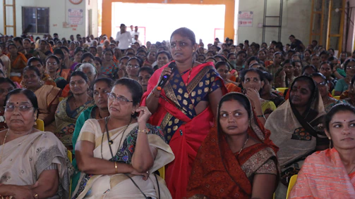 A warm photo of a woman confidently speaking in front of a small group of attentive women entrepreneurs.