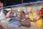 A group of women engaged in traditional craft workshop in a cozy village setting.