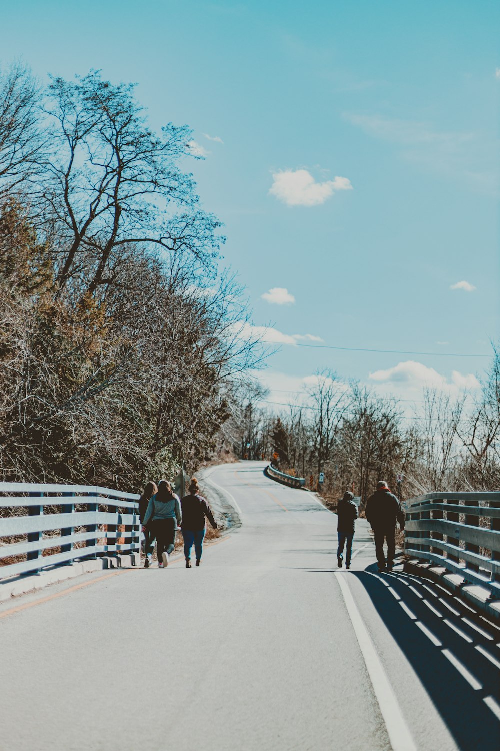 a group of people walking across a bridge