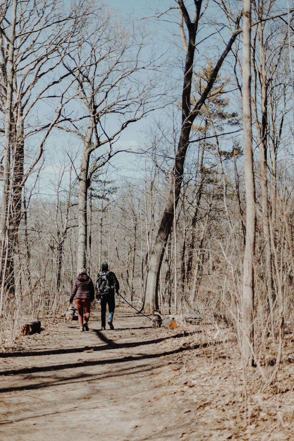 a couple of people walking down a dirt road