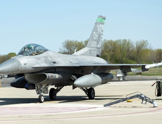 a fighter jet sitting on top of an airport tarmac