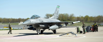 a fighter jet sitting on top of an airport tarmac