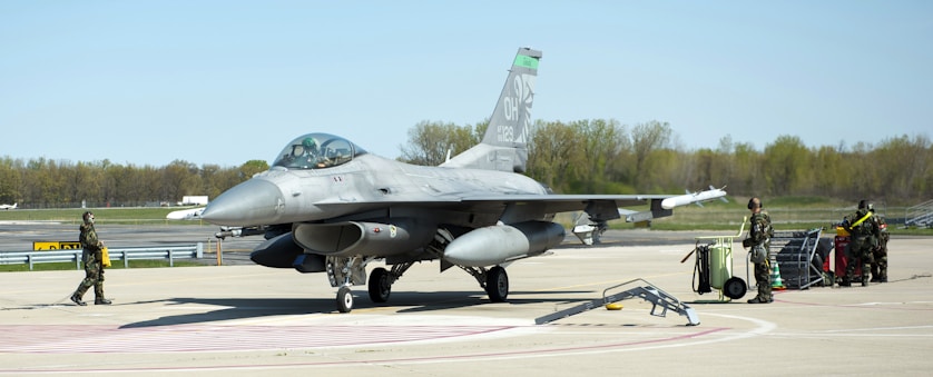 a fighter jet sitting on top of an airport tarmac
