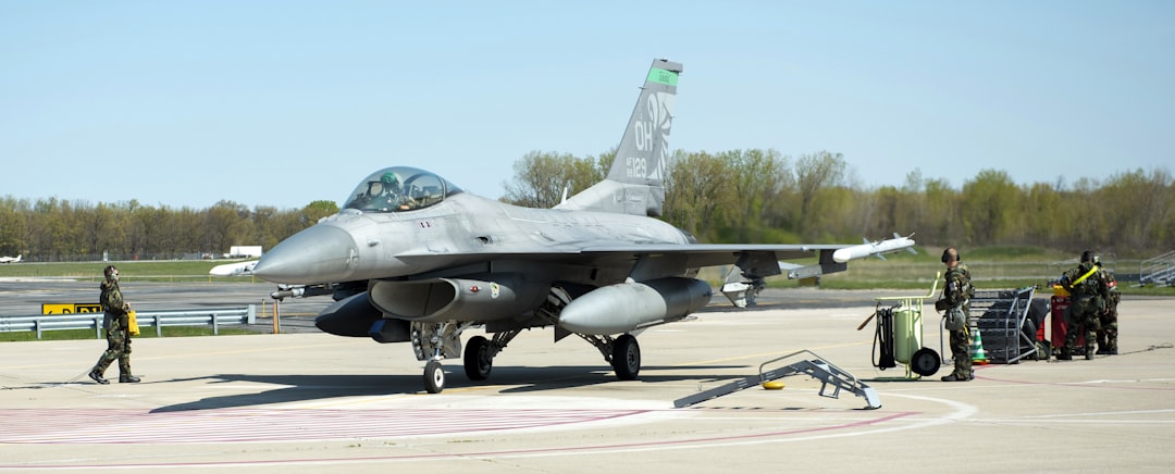 a fighter jet sitting on top of an airport tarmac, F-16 Fighting Falcon