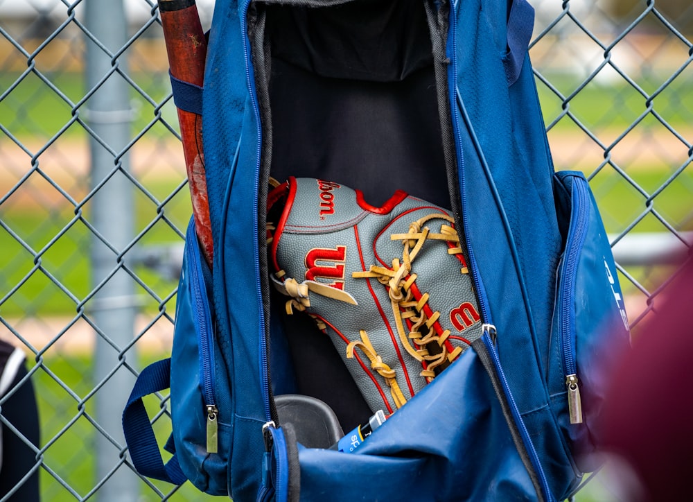 a catchers mitt in the back of a blue backpack