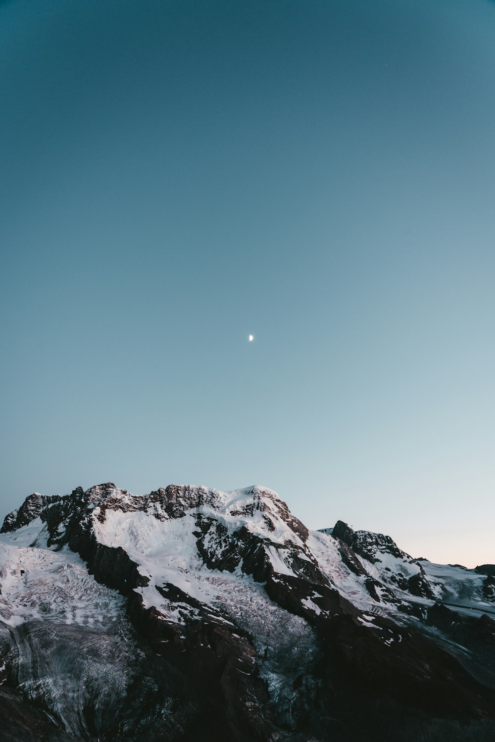 a snow covered mountain under a blue sky