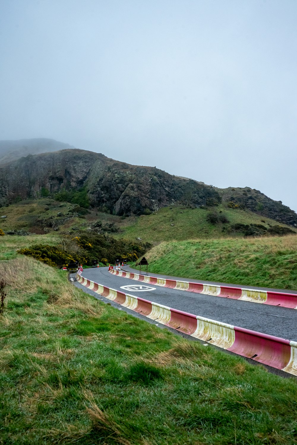 a curved road with a mountain in the background