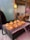 A culinary presentation of a dish displayed on a gridded platform with a backdrop of a softly lit interior. Each serving appears to have a creamy base topped with a delicate golden crispy element, possibly savory or sweet delicacies arranged artfully.