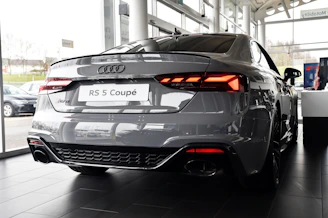 a grey car is parked in a showroom