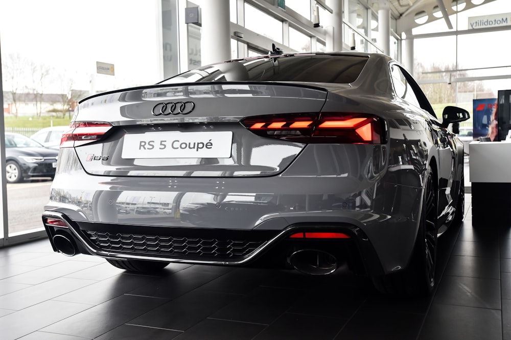 a grey car is parked in a showroom