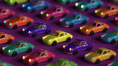 a group of toy cars sitting on top of a purple surface