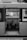 A bus is parked with its doors open, revealing a view of a few seats designated for disabled access inside. Outside, a group of workers in uniforms and helmets are visible near a truck, seemingly engaged in work or a discussion. The image is in black and white, emphasizing the tones and textures of the scene.