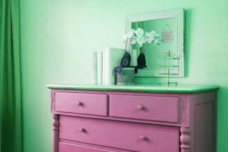 a blue dresser with flowers on top of it