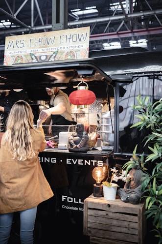 a woman standing in front of a food truck