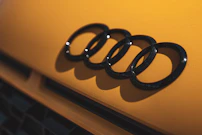 a close up of an audi logo on a yellow car