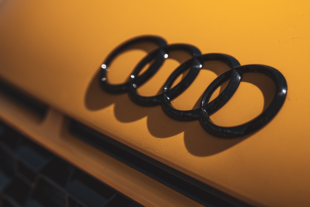 a close up of an audi logo on a yellow car