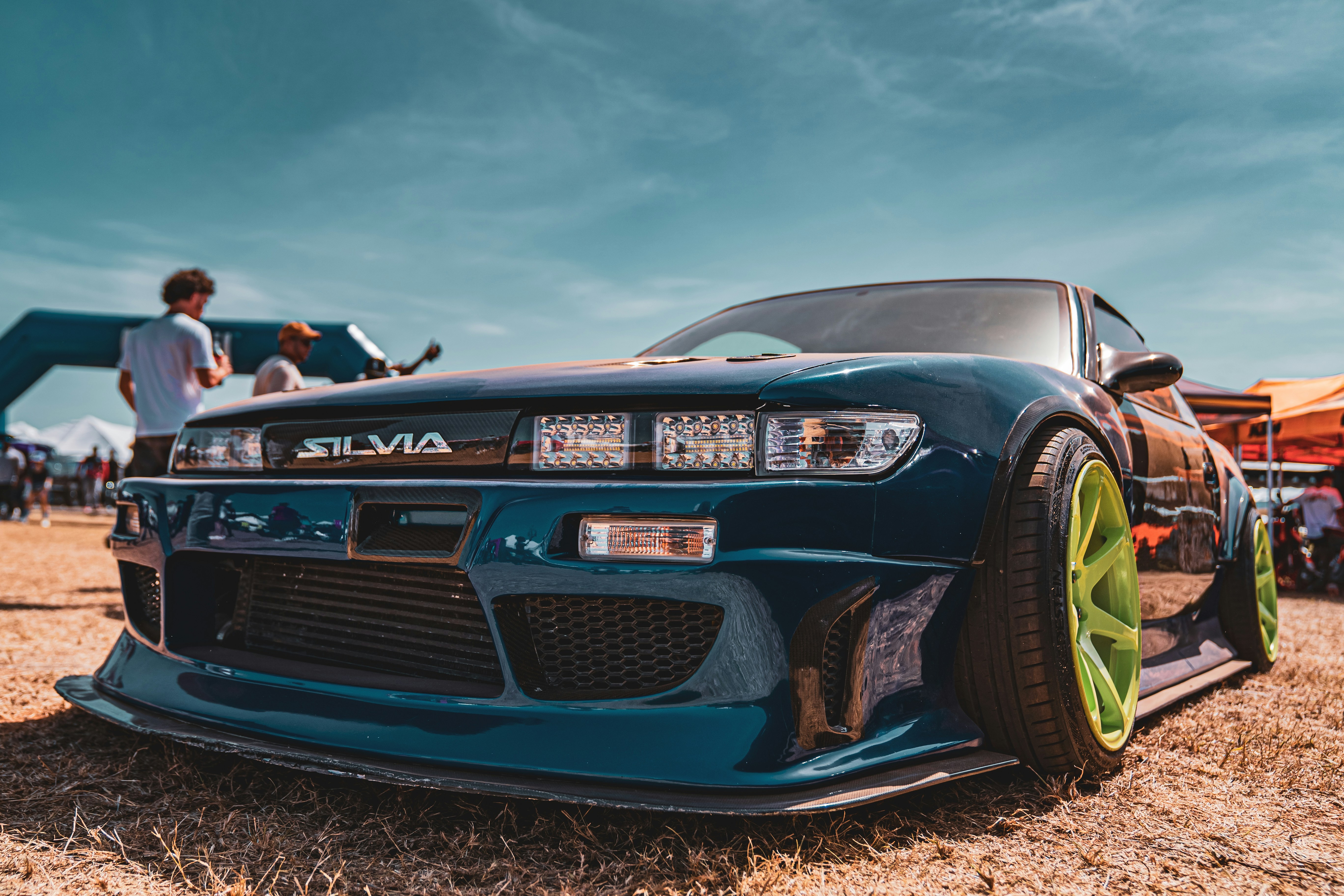 Foto zum Thema Ein blaues Auto, das auf einem trockenen Grasfeld