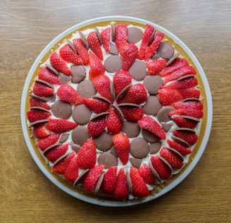 An elegant chocolate cake with smooth ganache and fresh strawberries arranged on top