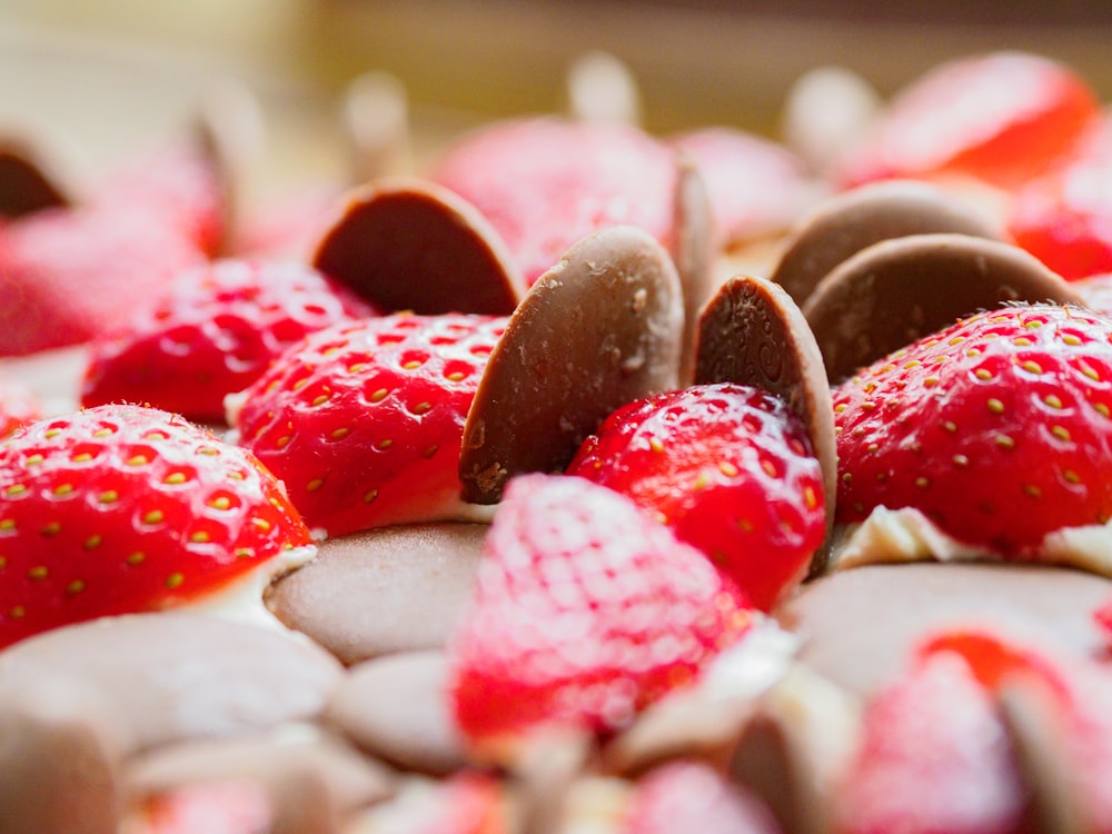 a pile of chocolate covered strawberries sitting on top of a table