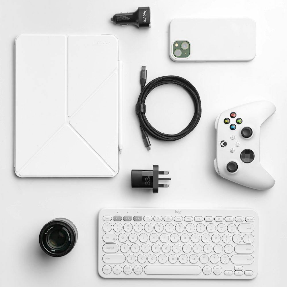 a white desk with a keyboard, mouse, and other electronics